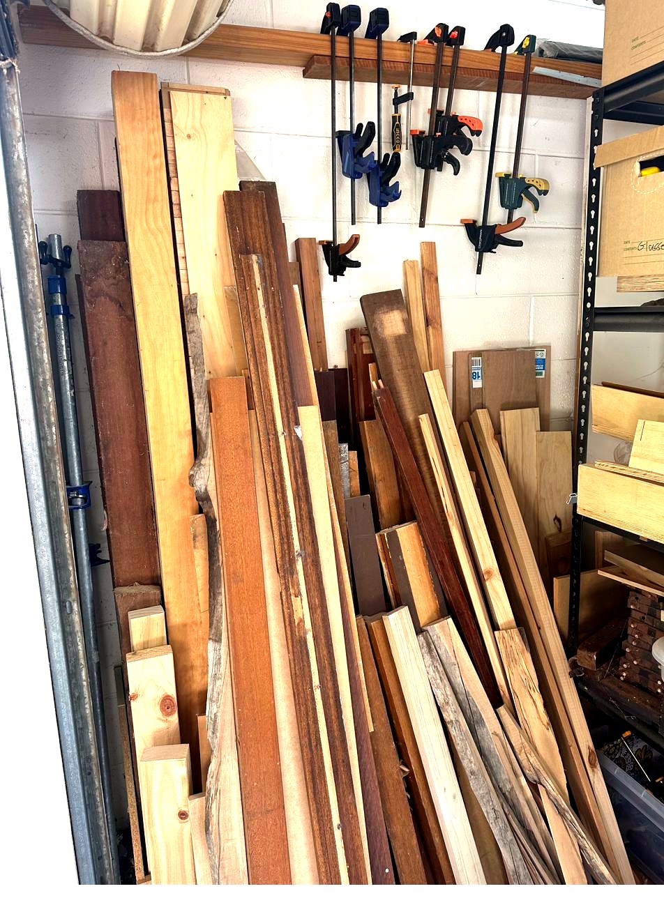 Timber store — Australian hardwood boards leaning against workshop wall